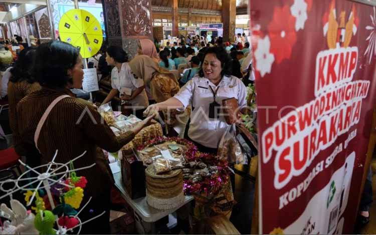 Pengunjung membeli makanan tradisional yang dijual saat Gelar Potensi Produk Unggulan Koperasi Kelurahan Merah Putih se-Kota Solo, Jawa Tengah, Rabu (26/11/2025). (ANTARA FOTO/Maulana Surya/foc.)