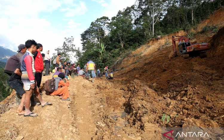 Warga menyaksikan operator alat berat saat membersihkan timbunan longsor yang menutupi badan jalan lintas Geumpang-Pameu-Takengon di Desa Panton Tengah, Rusip Antara, Aceh Tengah, Aceh, Rabu (24/12/2025). Pemerintah bersama TNI mengerahkan belasan alat berat untuk membersihkan badan jalan dari timbunan lumpur dan memperbaiki jalan amblas pascabencana hidrometeorologi Aceh. ANTARA FOTO/Irwansyah Putra/agr