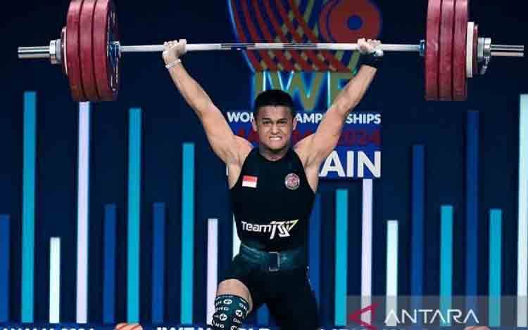 Lifter Indonesia Rizki Juniansyah melakukan angkatan dalam Kejuaraan Dunia Angkat Besi 2024 di Manama, Bahrain, Senin (9/12/2024). (ANTARA/HO-KONI Pusat/aa.)