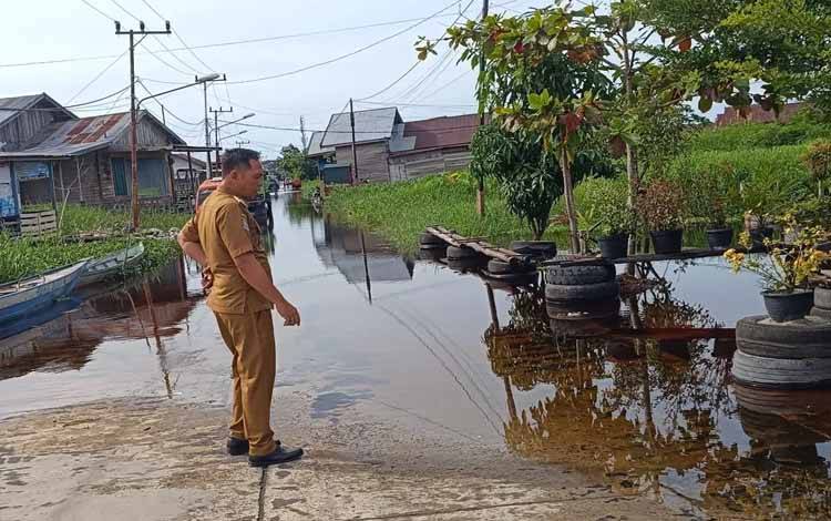 Plt Kalaksa BPBD Palangka Raya Hendrikus Satria Budi saat meninjau debit air di Jalan Ampi (Foto : IST)