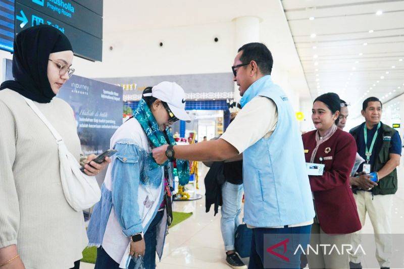 General Manager Bandara Internasional Syamsudin Noor Stephanus Millyas Wardana memberikan souvenir dan kain sasirangan khas Kalimantan Selatan kepada penumpang sebagai wujud dari keramahtamahan Bumi Lambung Mangkurat. (ANTARA/Firman)