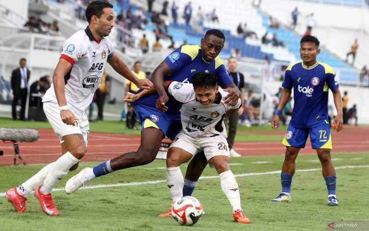 Pesepak bola Persik Kediri Yoga Adiyatama (dua kanan) bekerja sama dengan rekannya Ezra Harm Ruud Walian (kiri) untuk mempertahankan bola dari hadangan pesepak bola Arema FC Matheus Da Conceicao Nascimento (dua kiri) dan Bayu Setiawan (kanan) dalam pertandingan BRI Super League di Stadion Kanjuruhan, Malang, Jawa Timur, Minggu (11/1/2026). Arema mengalahkan Persik dengan skor akhir 2-1. ANTARA FOTO/ARI BOWO SUCIPTO