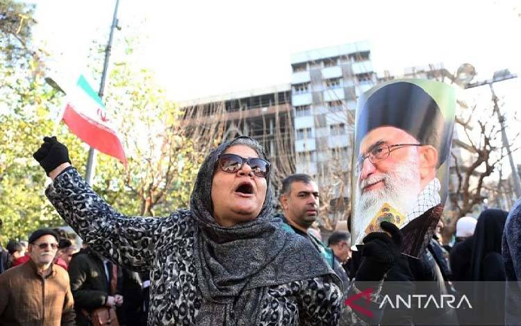 Seorang perempuan memegang foto Pemimpin Tertinggi Iran Ali Khameneisaat ikut serta dalam sebuah demonstrasi di Teheran, Iran, Senin (12/1/2026). Puluhan ribu warga pro-pemerintah turun ke jalan menanggapi seruan dari pihak berwenang Iran untuk menunjukkan solidaritas. ANTARA/Xinhua/Shadati/aa.