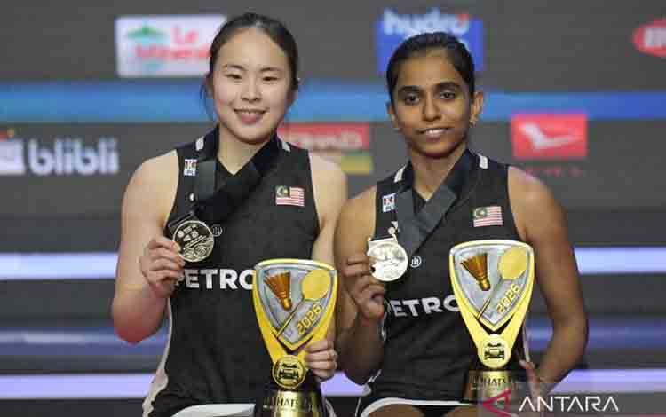 Pebulu tangkis ganda putri Malaysia Pearly Tan (kiri) dan Thinaah Muralitharan (kanan) berpose dengan medali dan piala mereka usai menjuarai Daihatsu Indonesia Masters 2026 di Istora Senayan, Jakarta, Minggu (25/1/2026). Ganda putri Malaysia itu memastikan gelar juara setelah lawan mereka, Arisa Igarashi/Miyu Takahashi dari Jepang, mundur karena Takahashi mengalami demam. ANTARA FOTO/Aditya Pradana Putra/YU (ANTARA FOTO/Aditya Pradana putra)