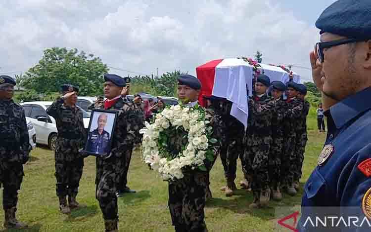 Petugas dari PSDKP mengiringi proses pemakaman jenazah Capt. Andy Dahananto pilot senior pesawat ATR 42-500 milik Indonesia Air Transport (IAT) di tempat pemakaman umum (TPU) Ranca Sadang, Desa Sodong, Tigaraksa, Kabupaten Tangerang, Banten pada Minggu siang (25/1).(ANTARA/Azmi Samsul M