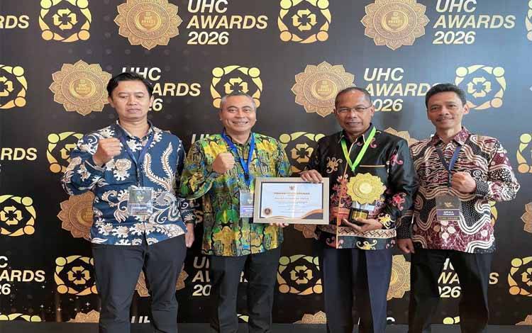 Kepala Dinas Kesehatan Provinsi Kalimantan Tengah, Suyuti Syamsul (dua dari kanan) didampingi Kepala BPJS Kesehatan Kantor Cabang Palangka Raya, K Hindro Kusumo (kanan) usai menerima penghargaan UHC.(FOTO: Istimewa)