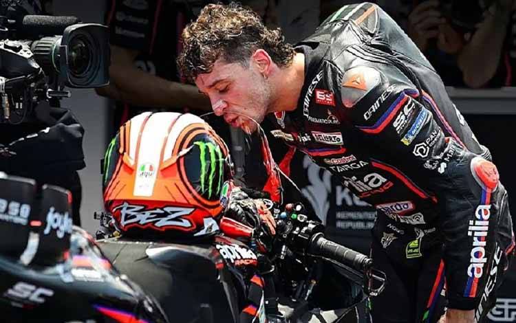 Pembalap Aprilia Racing Marco Bezzecchi mencium motor Aprilia RS-GP25. X/MotoGP