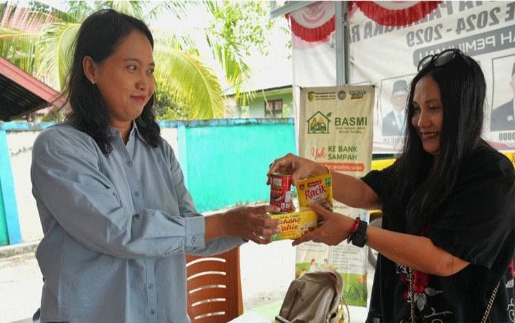 Seorang warga di Kelurahan Bukit Tunggal mendapatkan sembako setelah menukarkan sampah di Bank Sampah. (FOTO: HENDRI)