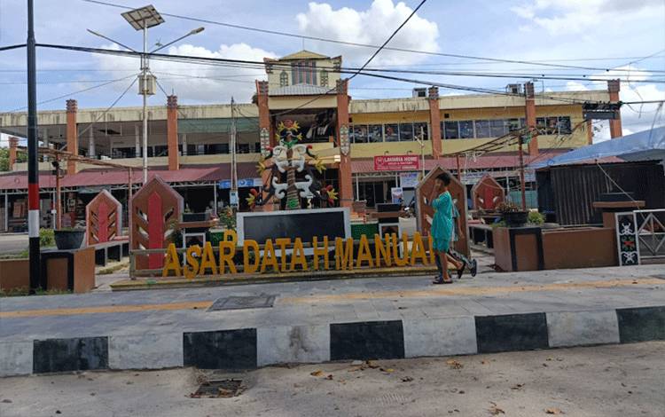 Seorang anak berjalan di depan Pasar Datah Manuah. (Foto:MARINI)