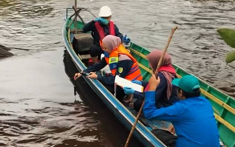 Staf?Laboratorium Lingkungan DLH Palangka Raya saat mengambil sampel air sungai di Pelabuhan Takaras. (Foto : IST)