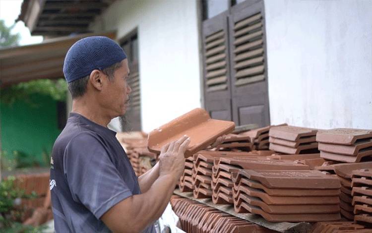 Seorang pengrajin menata genteng. ANTARA/HO - Bakom RI