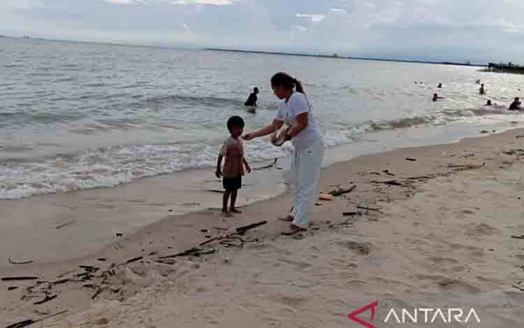 Ilustrasi - Seorang ibu menyuapi anaknya yang sedang bermain di Pantai Kilang Balikpapan, Kaltim. ANTARA/M Ghofar
