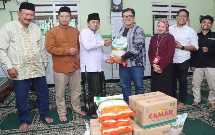 Media Relations Gabungan Pengusaha Kelapa Sawit Indonesia (GAPKI) Mochamad Husni (empat dari kanan) didampingi jajaran pengurus Forwatan menyerahkan bantuan bahan pokok kepada pimpinan pondok pesantren dan Panti Asuhan Riyadhush Sholihin Kebayunan di Depok, Jawa Barat. (Antara/HO/Dokumentasi pribadi)