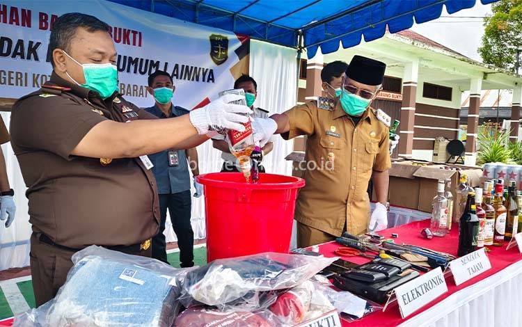 Wabup Kobar Suyanto bersama Kajari Kobar Nurwinardi saat memusnahkan miras. (Foto : Danang)