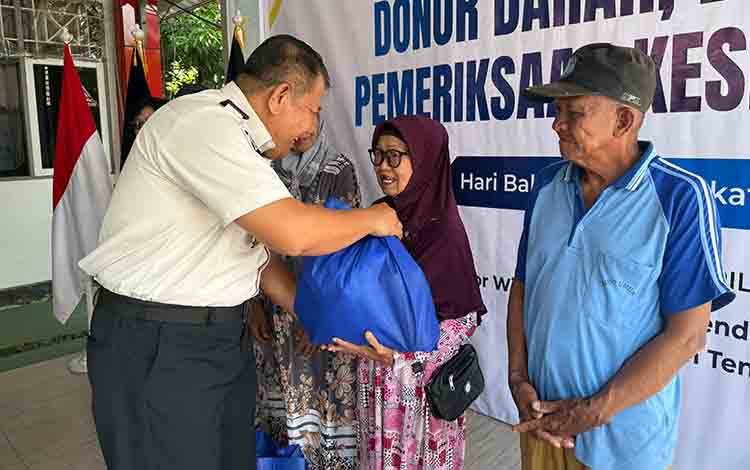 Kakanwil Ditjenpas Kalteng I Putu Murdiana saat membagikan paket sembako kepada masyarakat sekitar. (FOTO: IST)