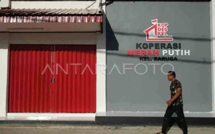 Seorang Bintara Pembina Desa (Babinsa) melintas di depan Gedung Koperasi Merah Putih Kelurahan Baruga yang telah rampung dibangun di Kendari, Sulawesi Tenggara, Kamis (19/2/2026). (ANTARA FOTO/Andry Denisah/foc.)