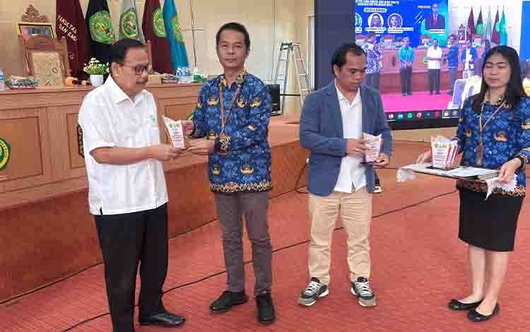 Sekretaris Eksekutif Gapki Cabang Kalimantan Tengah, Rawing Rambang (kemeja putih) menerima plakat penghargaan usai menjadi narasumber dalam kegiatan di Universitas Palangka Raya.(FOTO: Istimewa)