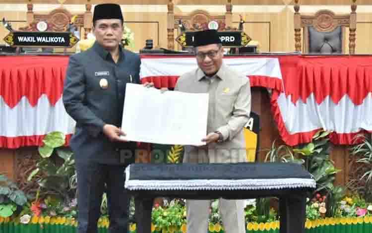 Ketua DPRD Kota Palangka Raya, Subandi saat menyerahkan dokumen rekomendasi kepada Wakil Wali Kota, Achmad Zaini. (FOTO: HUMAS)
