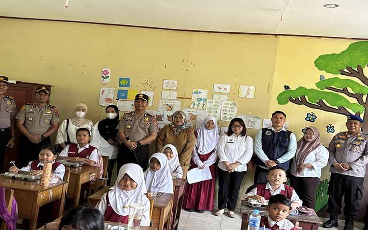Kepala SPPG Polres Pulang Pisau 01 bersama kapolres saat mengunjungi sekolah penerima manfaat MBG, Senin, 4 Mei 2026.( FOTO : RETHA)