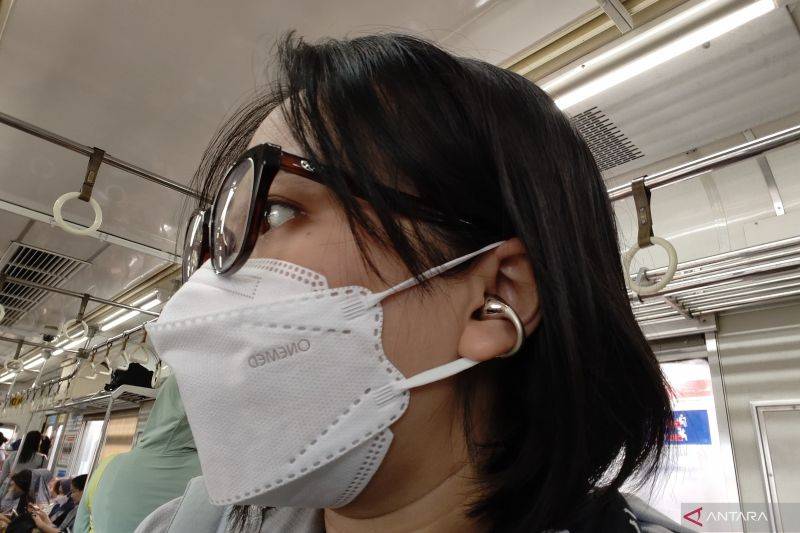 Tampilan realme Buds Clip berwarna Titanium Gold saat digunakan dalam perjalanan di KRL. (ANTARA/Livia Kristianti)