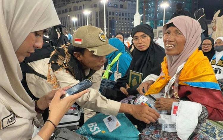Petugas haji dari Media Center Haji (MCH) menemani dan mengecek identitas seorang ibu yang terpisah dengan anaknya di kawasan Masjidil Haram, Makkah, Minggu (10/05/2026).(ANTARA/HO-MCH 2026.