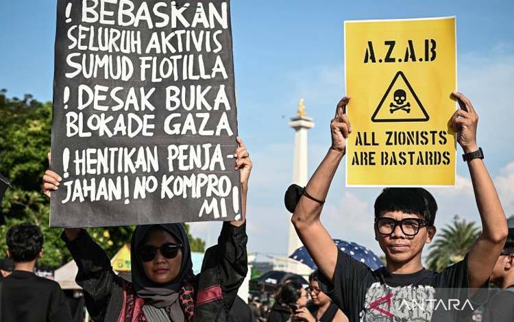 Relawan dari berbagai elemen memajang plakat tulisan dalam aksi solidaritas bagi WNI dan jurnalis yang diculik Israel di Jakarta, Kamis (21/5/2026). Mereka mengecam pencegatan Israel terhadap kapal-kapal misi kemanusiaan Global Sumud Flotilla menuju Gaza dan mendesak Pemerintah RI melalui Kementerian Luar Negeri segera melakukan langkah diplomatik guna memastikan keselamatan WNI yang berpartisipasi dalam misi tersebut. /ANTARA FOTO/Fauzan/nym.