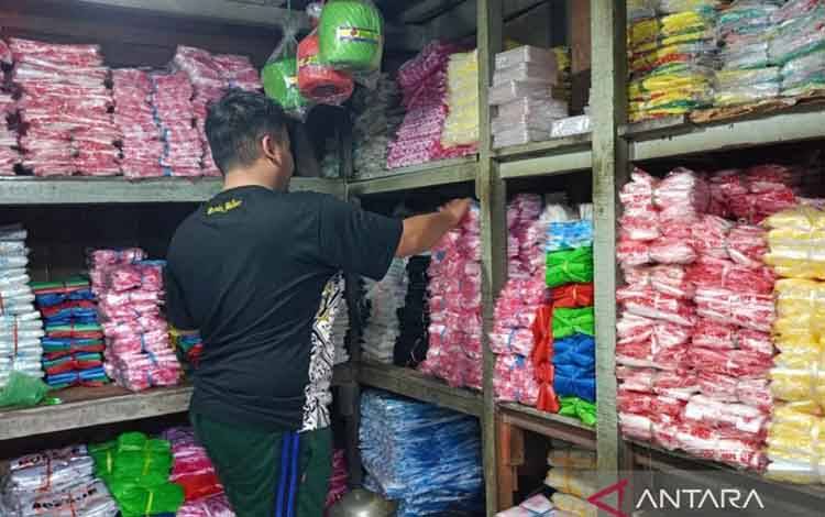 Seorang penjual berbagai macam plastik di Sidoarjo saat menata dagangannya di tengah kenaikan harga plastik di wilayah setempat. (ANTARA/Fahmi Alfian)