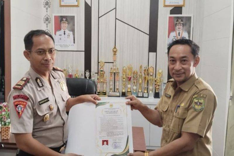 Kabid Kesmas di Dinkes Gumas Heriyanto (kanan) menyerahkan SLHS SPPG Kemala Presisi kepada Kabagops Polres AKP Nurheriyanto Hidayat di Kuala Kurun. ANTARA/HO-Dinkes Gumas