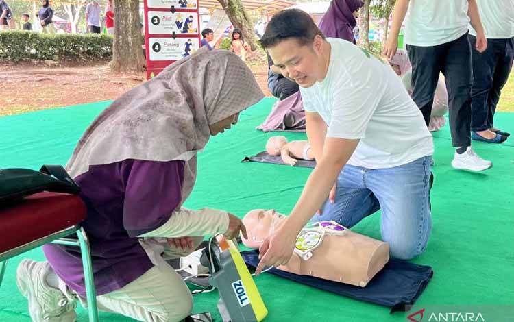 Ketua Unit Kerja Koordinasi Emergensi dan Terapi Intensif Anak (ETIA) Ikatan Dokter Anak Indonesia (IDAI) dr. Yogi Prawira, Sp.A., Subsp.ETIA(K) (kanan) memberikan edukasi Bantuan Hidup Dasar (BHD) kepada masyarakat saat peringatan HUT ke-72 IDAI di Taman Margasatwa Ragunan, Jakarta, Minggu (14/6/2026). ANTARA/Farika Nur Khotimah