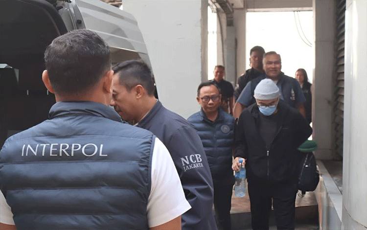 Anggota Divhubinter Polri menggiring bos asuransi Kresna Life, Michael Steven (depan kanan), yang menjadi buronan internasional dan diekstradisi dari Maroko. (ANTARA/HO-Divisi Hubungan Internasional Polri)