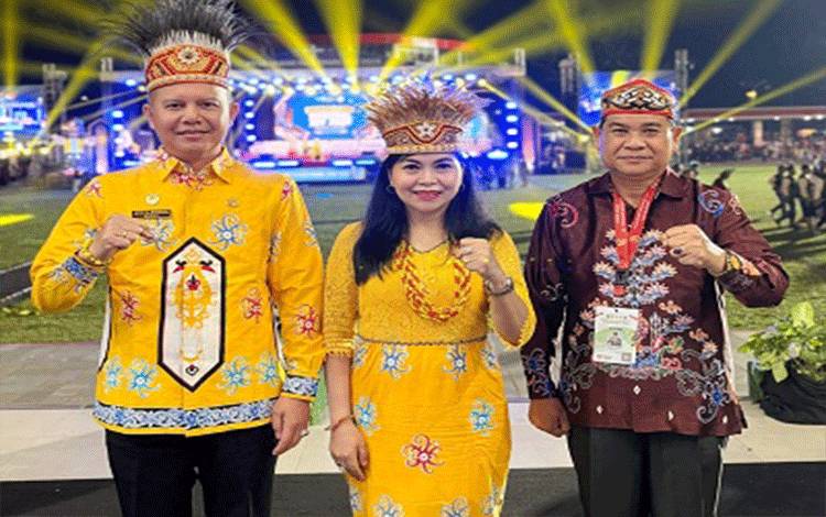 Ketua LPPD Kalteng, Guntur Talajan (kanan) berfoto dengan Bupati Gunung Mas, Jaya S Momong yang didampingi istrinya, saat menghadiri penutupan Pesparawi Nasional XIV, di Manokwari, Papua Barat pada Minggu malam, 28 Juni 2026. (FOTO: Istimewa)