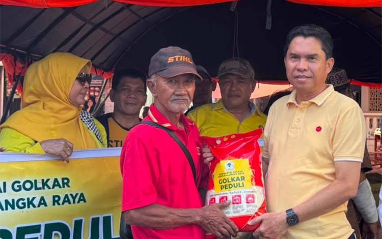 Ketua Fraksi Partai Golkar DPRD Kota Palangka Raya Sudarto menyerahkan bantuan kepada korban kebakaran. (FOTO: MARINI)