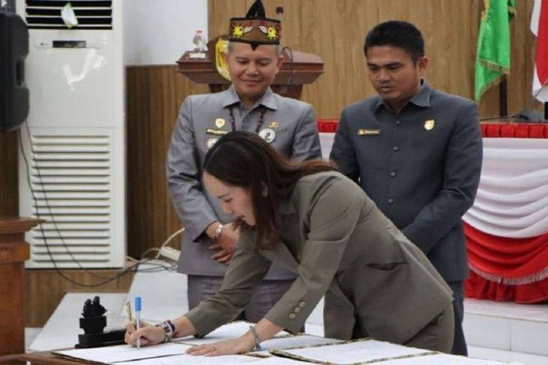 Wakil Ketua I DPRD Gumas Nomi Aprilia disaksikan Bupati Jaya S Monong dan Ketua DPRD Binartha, menandatangani nota kesepakatan bersama, saat rapat paripurna di Kuala Kurun. ANTARA/HO-Diskominfosantik Gumas.