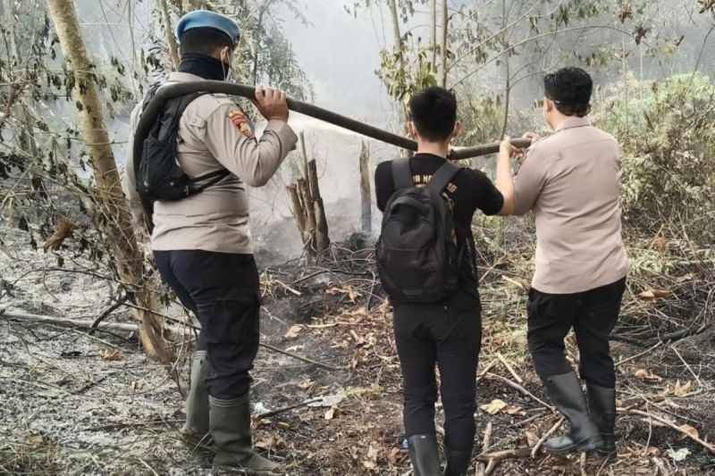 Kapolres Barito Selatan AKBP Eko Mardianto memadamkan api di Jalan Buntok- Palangka Raya. ANTARA/Dokumen Pribadi