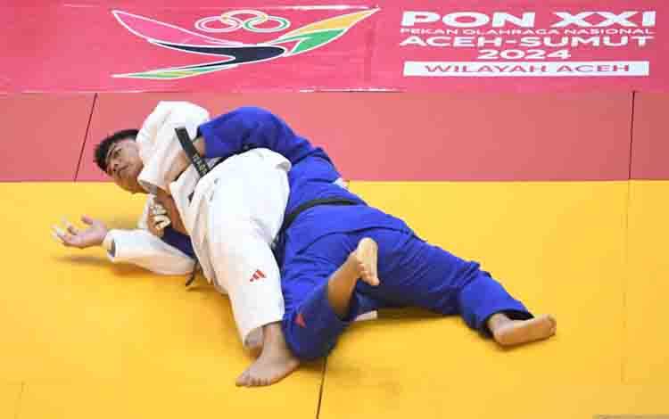 Judoka Jawa Barat Rafi Fadilah (kanan) berusaha mengunci judoka Bali Gede Agastya D Wardana (kiri) pada babak final nomor +100 kg putra PON XXI Aceh-Sumut 2024 di GOR Universitas Syiah Kuala, Banda Aceh, Aceh, Kamis (12/9/2024). Rafi Fadilah menang dalam pertandingan tersebut dan berhasil meraih emas, diikuti peraih medali perak Gede Agastya D Wardana serta peraih medali perunggu judoka DKI Jakarta Ardo Bambasta dan judoka Jawa Tengah Ranadika Made Prakasa. ANTARA FOTO/Syifa Yulinnas/aww.
