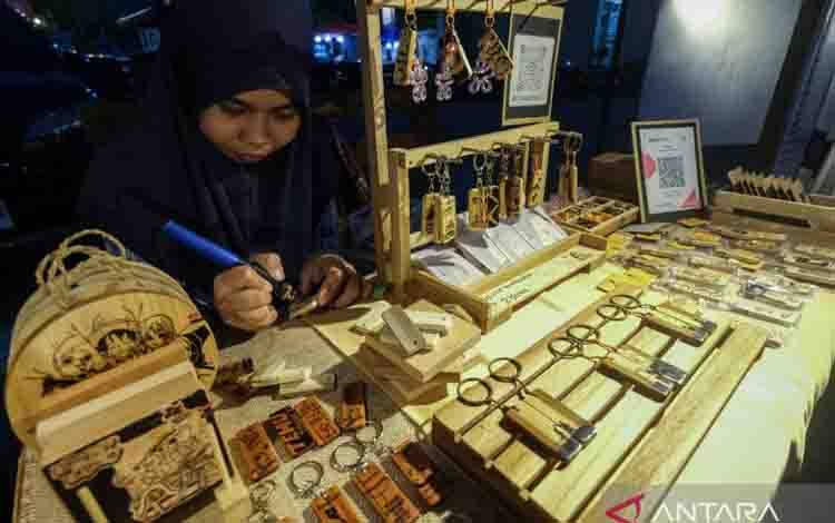 Perajin membuat gantungan kunci dengan teknik pirografi di Kendari, Sulawesi Tenggara, Jumat (24/7/2026). Kementerian Perindustrian memperkuat pembinaan industri kecil menengah (IKM) sektor kreatif sektor fesyen dan kriya agar mampu menangkap peluang pasar dengan memahami perilaku konsumen untuk menghasilkan produk yang relevan dan berdaya saing tinggi. ANTARA FOTO/Andry Denisah/rwa.