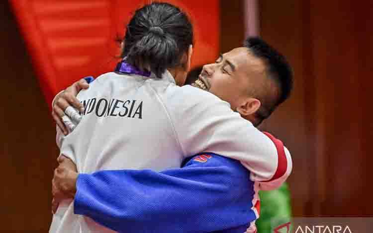 Pejudo Indonesia Junaedi (kanan) berpelukan dengan ofisial tim Indonesia seusai menang atas pejudo India Kapil Palmar pada pertandingan semifinal nomor J1-70 kg putra cabang olahraga judo Asian Para Games 2026 di Hall Prefectural Martial Arts, Aichi, Jepang, Senin (19/10/2026). Junaedi melaju ke final setelah mengalahkan Kapil Palmar dengan ippon. ANTARA FOTO/Mohammad Ayudha/tom. (ANTARA FOTO/MOHAMMAD AYUDHA)